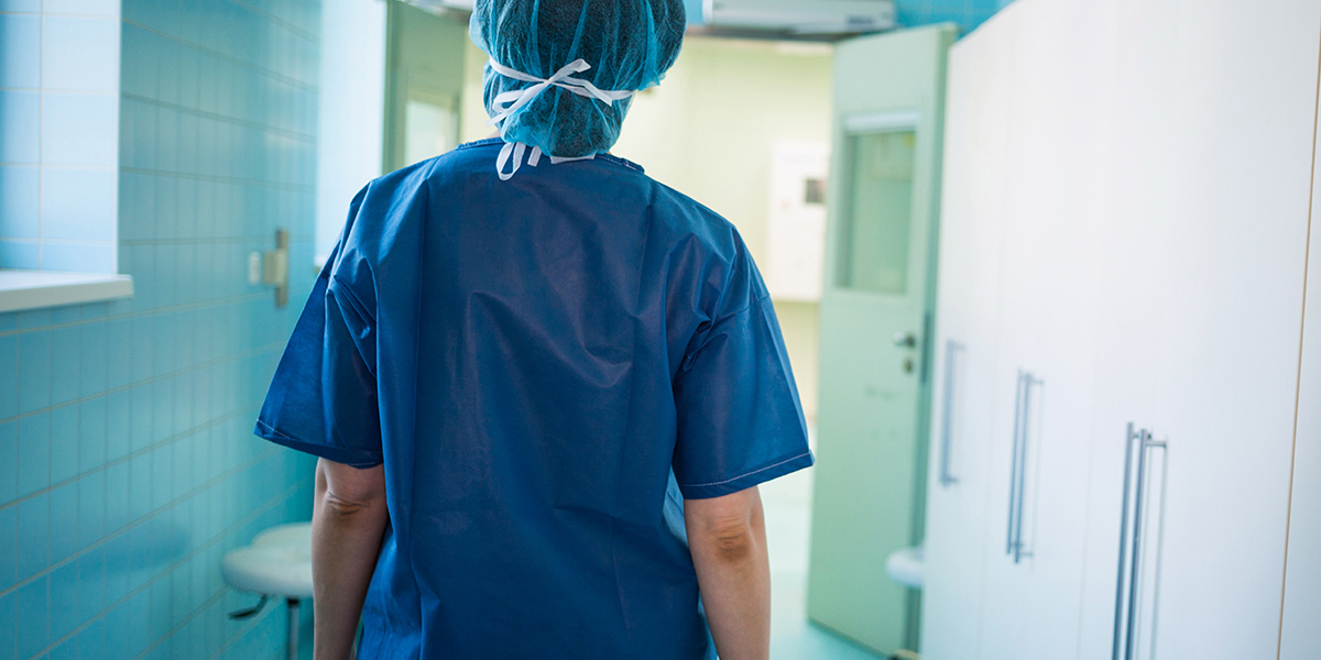 Enfermera camina por pasillo de hospital